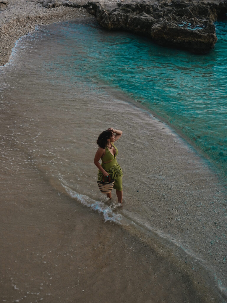 Gabby walking on a private beach with crystal blue waters at sunset
